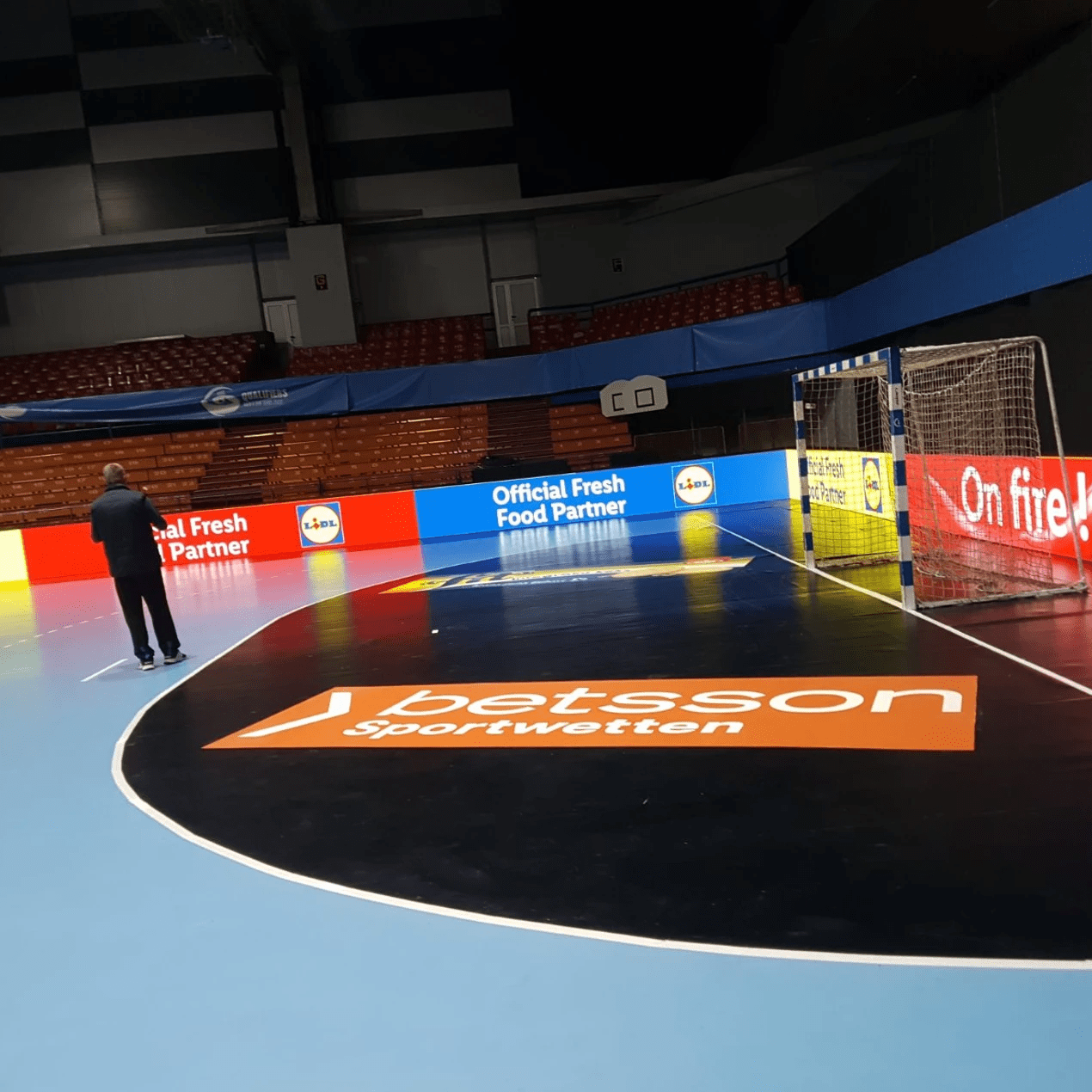 Indoor arena with Lidl and Betsson LED boards around the court